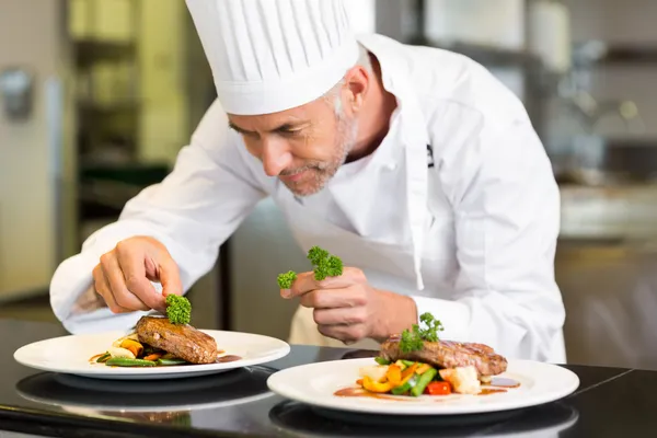 Professional chef plating a fine-dining dish